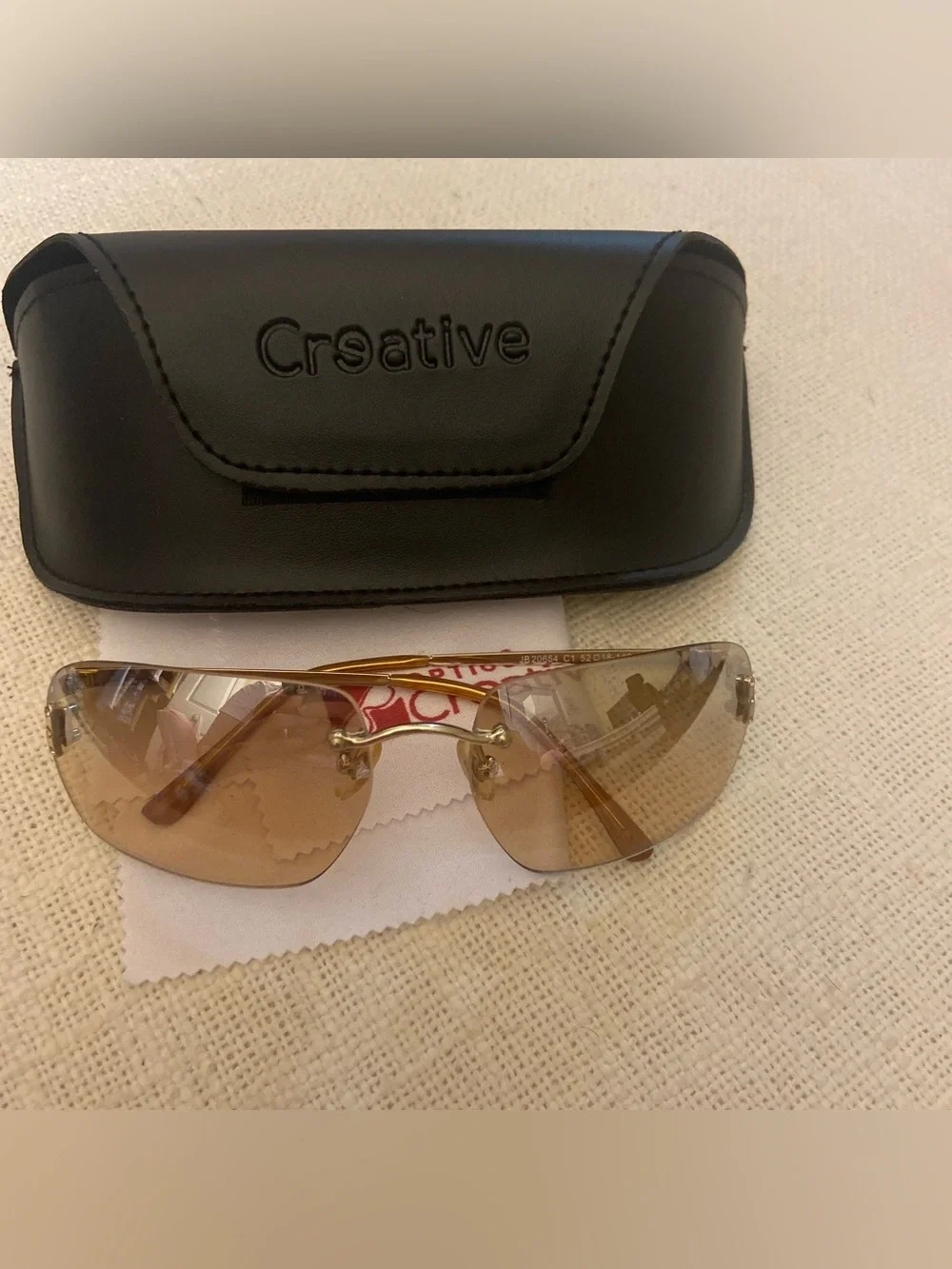 2000s style creative optics sunglasses with brown lenses and gold frames